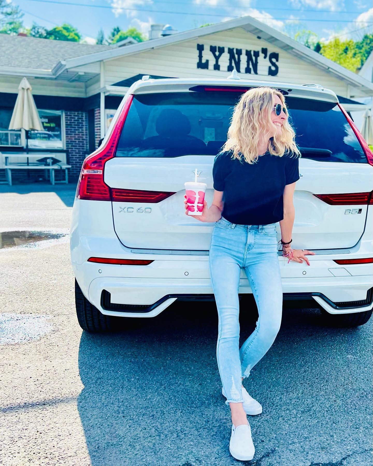 Nicole leaning on a Volvo at Lynn's roadside diner